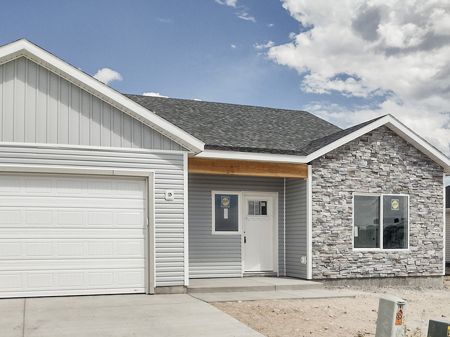 Charming Brown home with covered front porch, gable roof, and 2-car garage